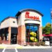 Chick-fil-A restaurant exterior in Manassas, Virginia, featuring the logo, drive-thru, and an American flag.