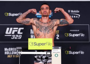 Max Holloway flexing on the scale during the UFC 329 weigh-in.