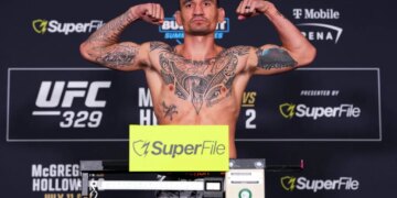Max Holloway flexing on the scale during the UFC 329 weigh-in.