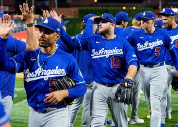The Los Angeles Dodgers baseball team, including Max Muncy (13), Mookie Betts, and Freddie Freeman (5), high-fiving.