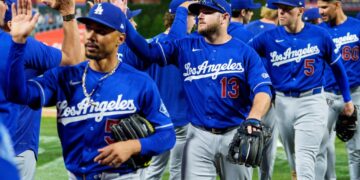 The Los Angeles Dodgers baseball team, including Max Muncy (13), Mookie Betts, and Freddie Freeman (5), high-fiving.