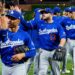 The Los Angeles Dodgers baseball team, including Max Muncy (13), Mookie Betts, and Freddie Freeman (5), high-fiving.