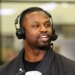 Former NFL player Bart Scott speaking into a microphone while wearing headphones.