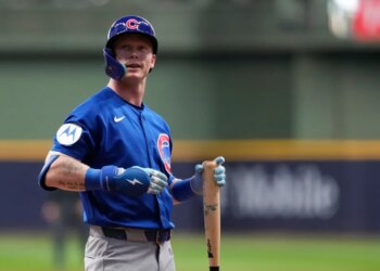 Pete Crow-Armstrong, a Chicago Cubs player, stands on the baseball field holding a bat.