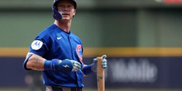 Pete Crow-Armstrong, a Chicago Cubs player, stands on the baseball field holding a bat.