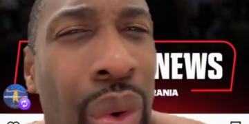 A man's face close up with a basketball player in a "76ers" jersey in the background.