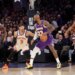 LeBron James of the Lakers dribbles the ball while being defended by Josh Hart of the Knicks.