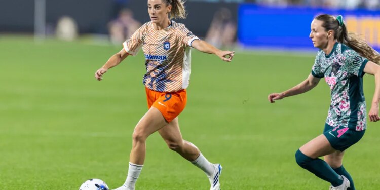 Gotham FC's Esther González dribbles the ball down the pitch as Washington Spirit's Gabrielle Carle chases her.