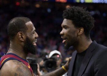 LeBron James and Joel Embiid talking on a basketball court.