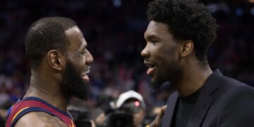 LeBron James and Joel Embiid talking on a basketball court.