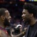 LeBron James and Joel Embiid talking on a basketball court.