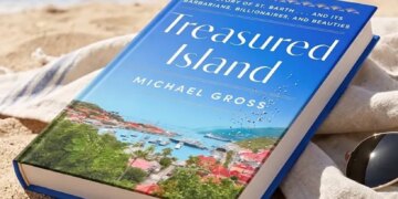 Treasured Island by Michael Gross, on a beach with the ocean and hills in the background.