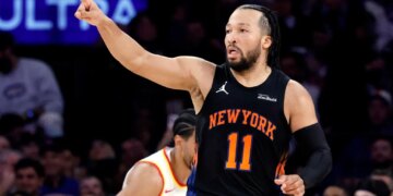 New York Knicks guard Jalen Brunson points while running during an NBA playoff game.