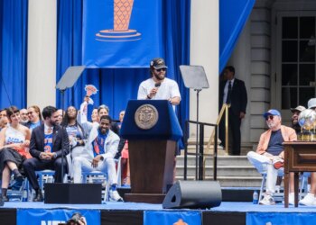 Knicks player Jalen Brunson speaks at a podium to celebrate the team's key to the city ceremony at City Hall.