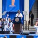 Knicks player Jalen Brunson speaks at a podium to celebrate the team's key to the city ceremony at City Hall.