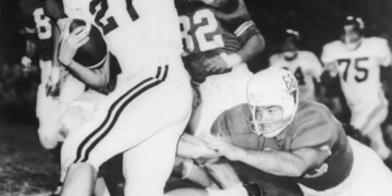 Jim Lindsey (21) Arkansas back gallops for eight yards before Texas' Barney Giles (68) made a dive to trip him up in the first quarter