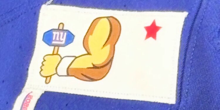 Giants patches, a hand holding a sign with "ny" on it and a red star, on a blue jersey.