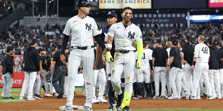 New York Yankees shortstop José Caballero is escorted off the field after a scuffle with Pittsburgh Pirates pitcher Dennis Santana.