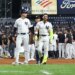 New York Yankees shortstop José Caballero is escorted off the field after a scuffle with Pittsburgh Pirates pitcher Dennis Santana.