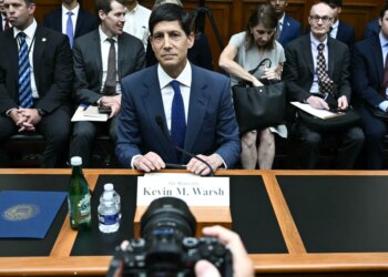 Kevin M. Warsh at a hearing with others seated behind him.