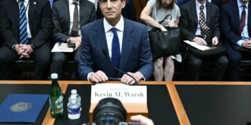 Kevin M. Warsh at a hearing with others seated behind him.