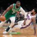 Boston Celtics player Jaylen Brown drives to the basket as Philadelphia 76ers player Paul George falls to the ground.
