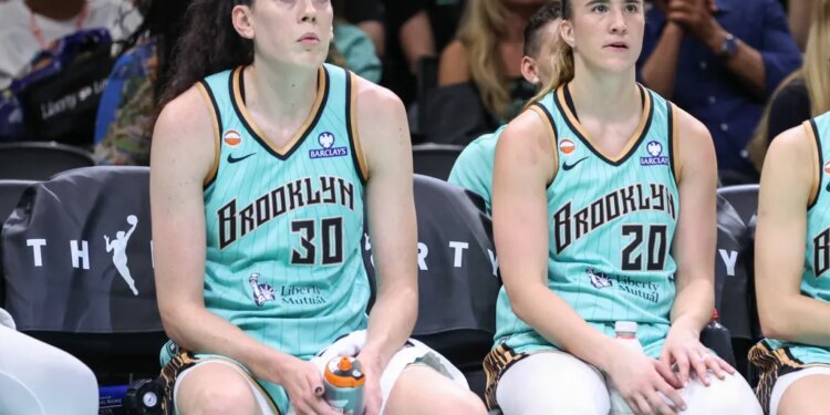 Breanna Stewart (left) and Sabrina Ionescu wear dejected expressions on the bench during the Liberty's loss to the Wings on July 7, 2026.