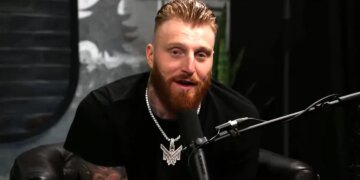 Maxx Crosby speaking into a microphone.