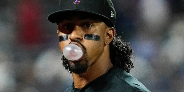 New York Mets' Francisco Lindor blowing a bubble with gum during a baseball game.