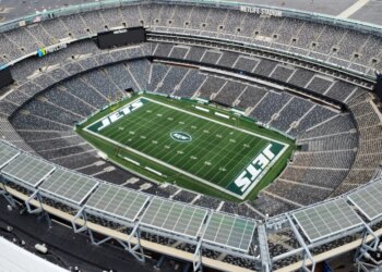 Aerial view of MetLife Stadium, home to the New York Jets and Giants, showing the empty stands and the "JETS" logo on the football field.