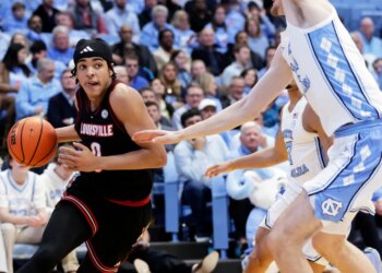 Louisville guard Mikel Brown Jr. drives against North Carolina center Henri Veesaar during a basketball game.
