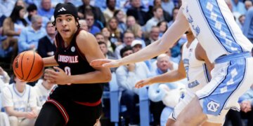 Louisville guard Mikel Brown Jr. drives against North Carolina center Henri Veesaar during a basketball game.