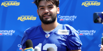 Los Angeles Rams player Stetson Bennett in a blue jersey speaking at a press conference.