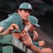 Boston Red Sox's Roman Anthony, sidelined with an injured right wrist, watches from the dugout rail.