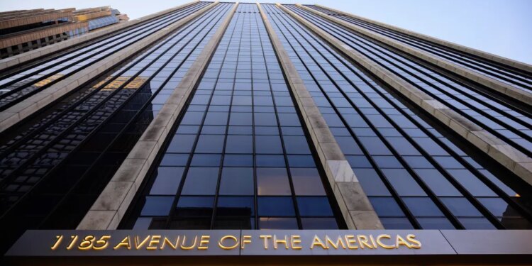 The facade of 1185 Avenue of the Americas, a skyscraper in Manhattan, New York, with its name illuminated in gold at the bottom.