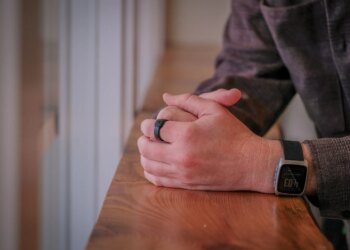 An image of a person wearing a black ring on their finger.