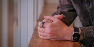 An image of a person wearing a black ring on their finger.