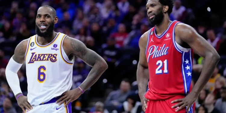 LeBron James of the Los Angeles Lakers and Joel Embiid of the Philadelphia 76ers stand on the court during an NBA basketball game.