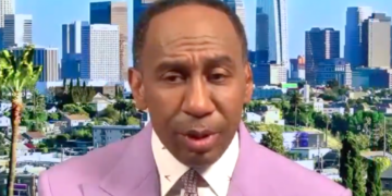 Stephen A. Smith in a lavender suit with a city skyline in the background.