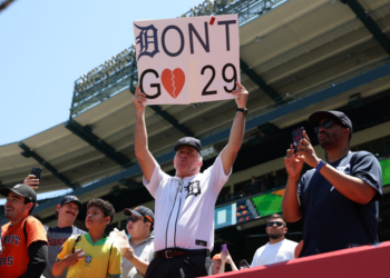 A Detroit Tigers fan holding a sign that says "Don't Go" with a broken heart symbol and the number 29.