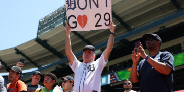 A Detroit Tigers fan holding a sign that says "Don't Go" with a broken heart symbol and the number 29.
