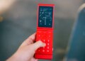 A red flip phone, open, showing directions.