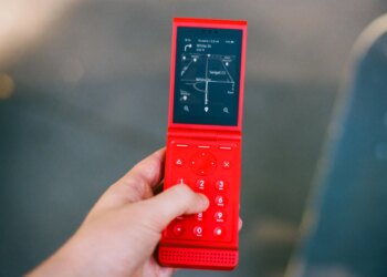 A red flip phone, open, showing directions.