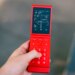 A red flip phone, open, showing directions.