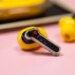 The Nothing Ear 3A earbuds on a mauve background with their case.