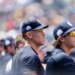 Aaron Judge in the dugout wearing a Yankees cap with a "Play Ball Weekend" patch.