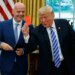 Donald Trump holding up a red card while Gianni Infantino smiles beside him.