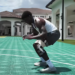 A man wearing a knee brace squats on a basketball court.