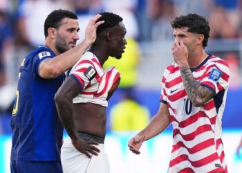 Bosnia's Sead Kolasinac pats United States' Folarin Balogun on the head as United States' Christian Pulisic stands by after receiving a red card.