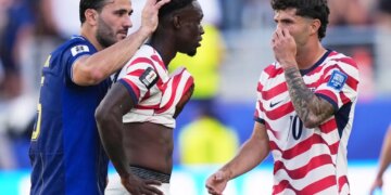 Bosnia's Sead Kolasinac pats United States' Folarin Balogun on the head as United States' Christian Pulisic stands by after receiving a red card.